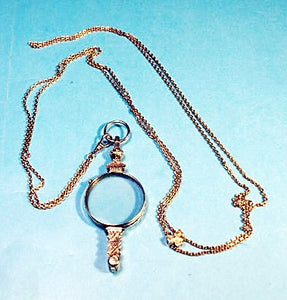 Antique gold folding eyeglasses on long chain.