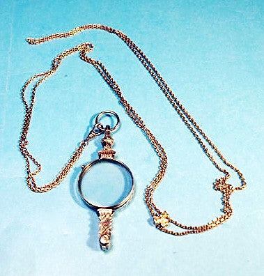 Antique gold folding eyeglasses on long chain.