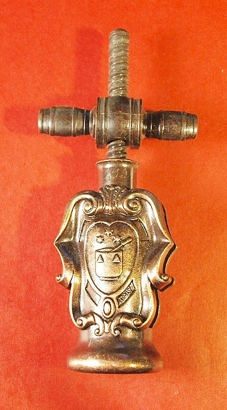 Vintage corkscrew with crest in copper tones.
